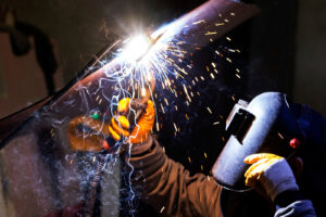 Worker welding with an oxy-acetylene torch